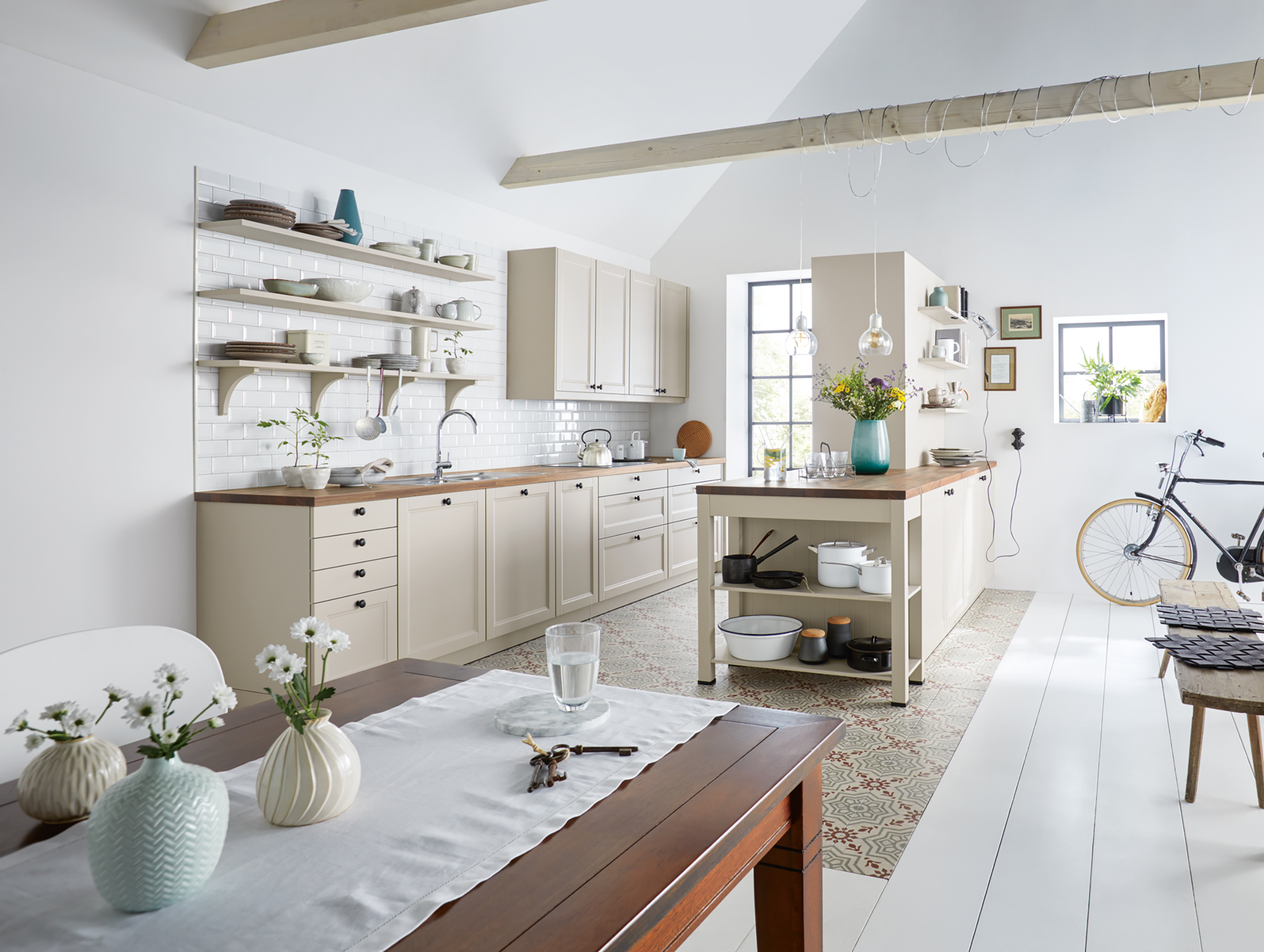Helle Landhausküche mit Tischgestell und Wandregalen im Landhausstil